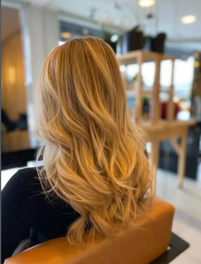 Lang goudblond haar met warme balayage, gekleurd bij Le Salon